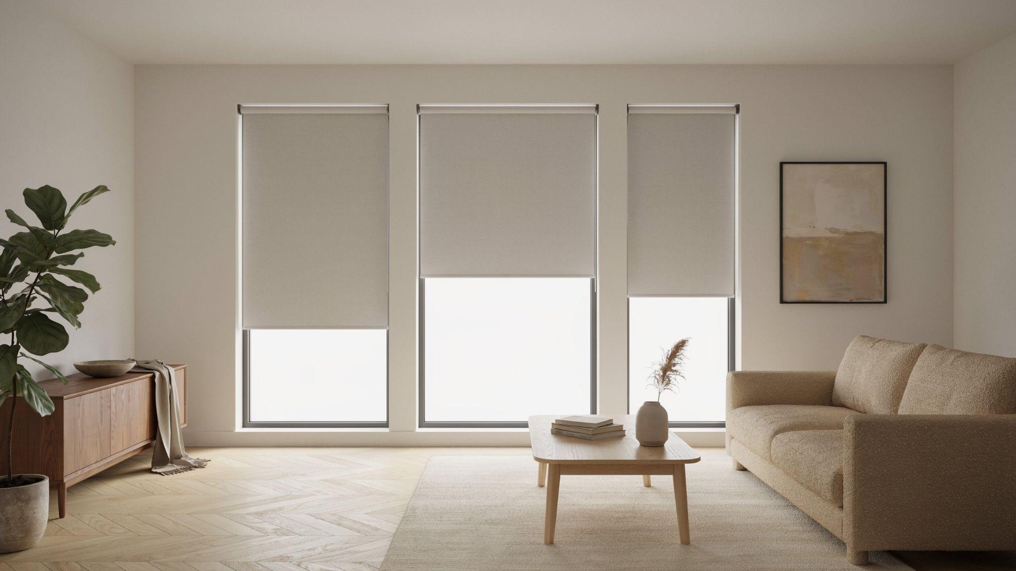 Matching roller blinds creating a sleek modern look across three windows.