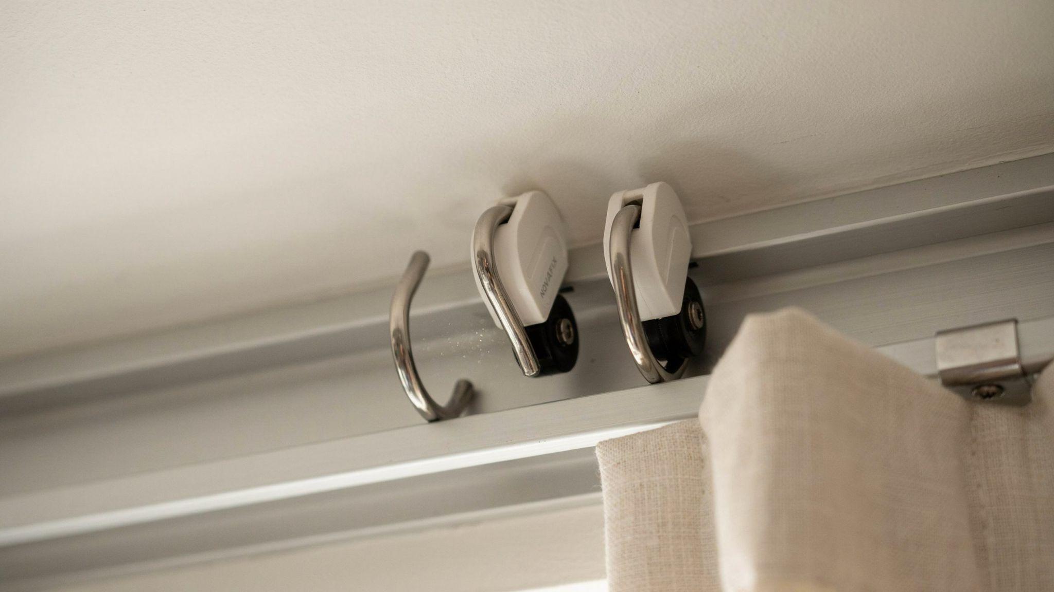 Carrier hooks attached to sliding curtain track carriers.