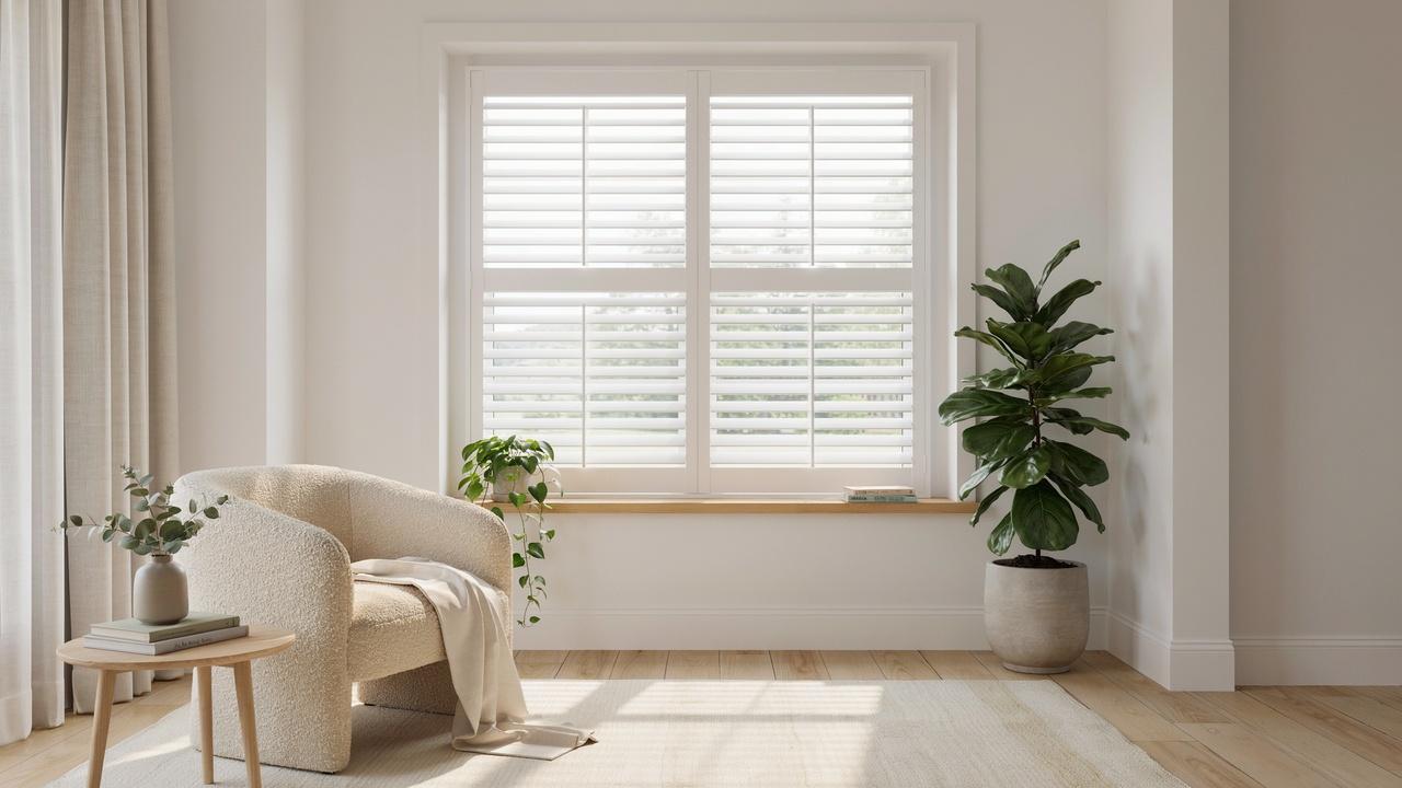 Bright modern living room featuring inside mount plantation shutters fitted neatly within a deep window frame.