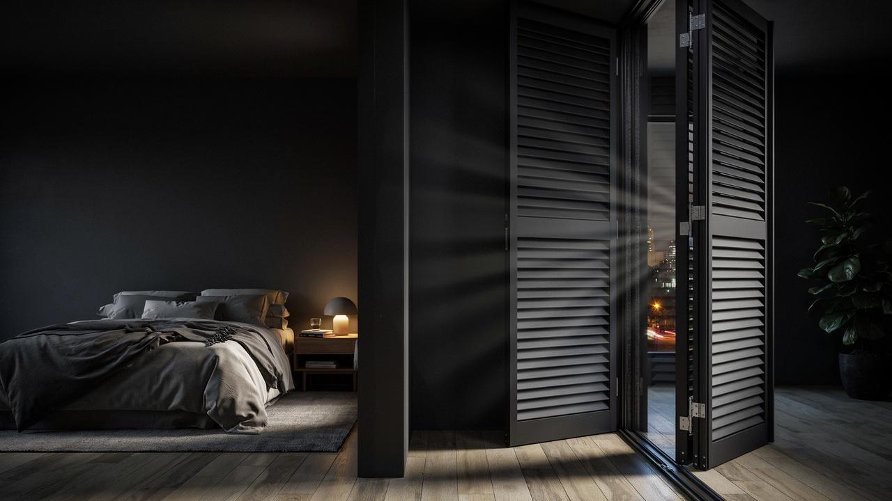Dual-layer insulated blackout shutters in a bedroom designed to block light and reduce outside noise.