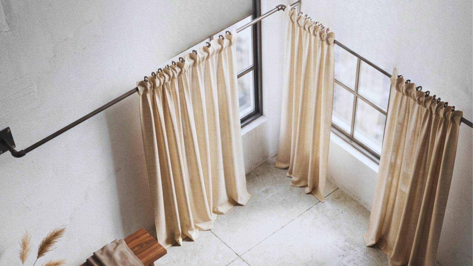 corner window with L shaped pipe curtain rod using elbow joints and wall flanges for smooth wrap around industrial modern interior design scene.