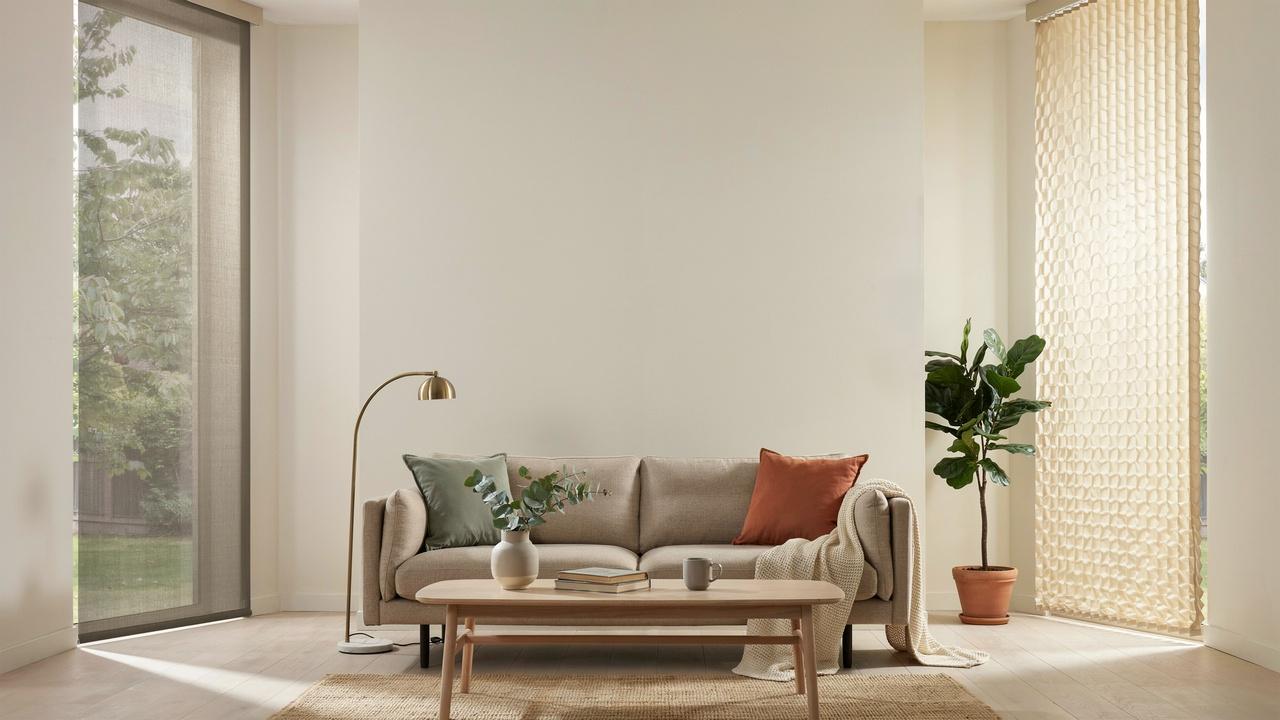 Minimalist room with tall solar shade on left and textured cellular shade on right window.