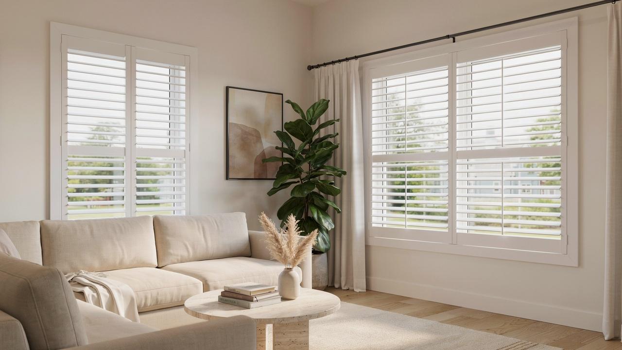 Modern living room showing side-by-side comparison of inside mount and outside mount plantation shutters on two windows.