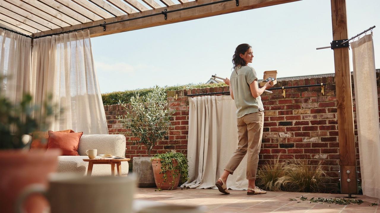 Different outdoor curtain styles displayed on a patio to help choose the right option for an outdoor space.