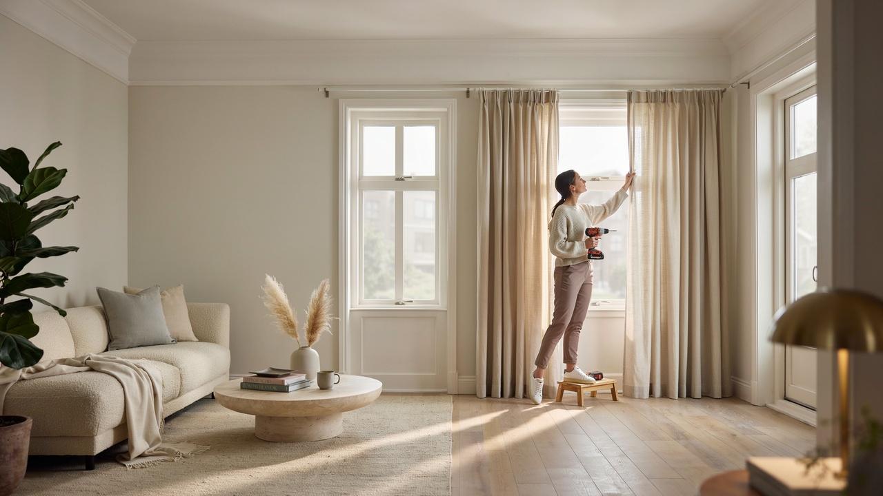 A modern living room showing floor-length curtains installed just below decorative crown molding.