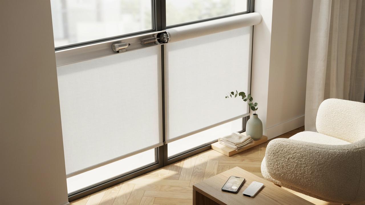 Modern motorized blinds with a visible internal motor mechanism and remote control in a contemporary living room.