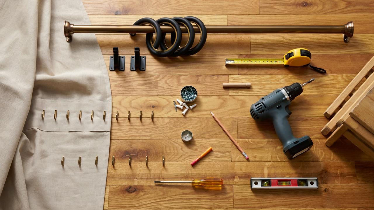 Curtain hooks, rings, rod, and installation tools neatly arranged for a DIY curtain hanging project.