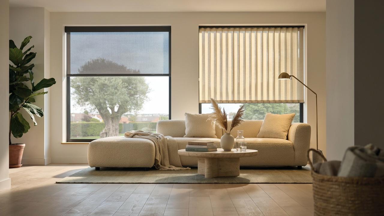 Modern living room with dark solar shade on left and light sheer cellular shade on right windows.