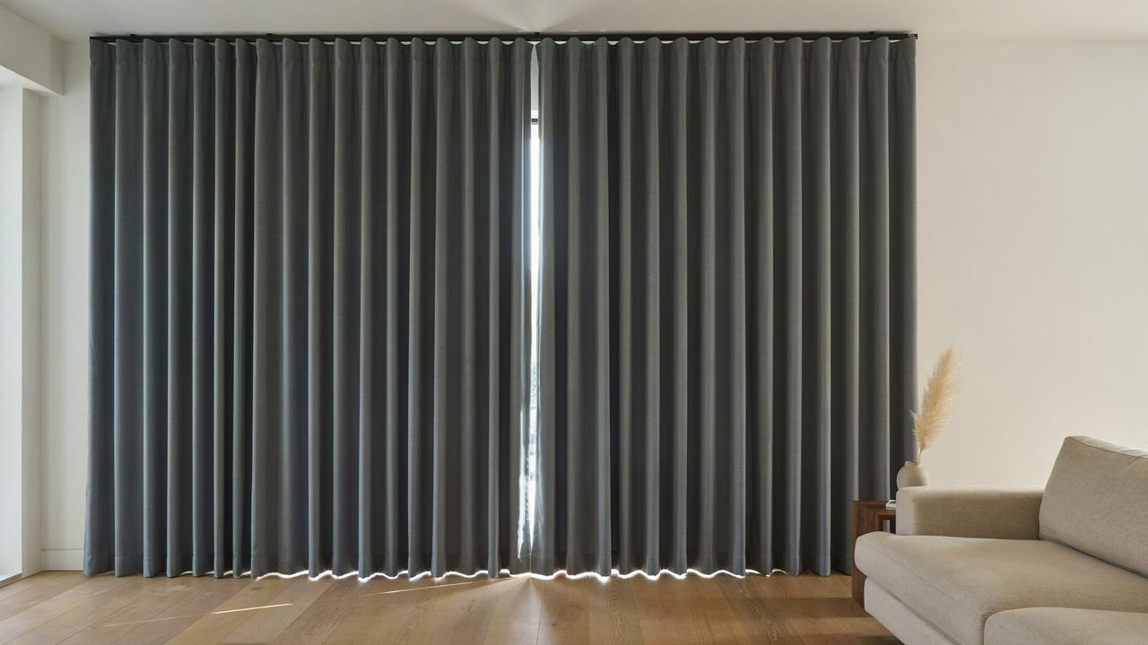 Thermal-lined curtains with reflective backing installed over a window to improve insulation and reduce indoor heat.