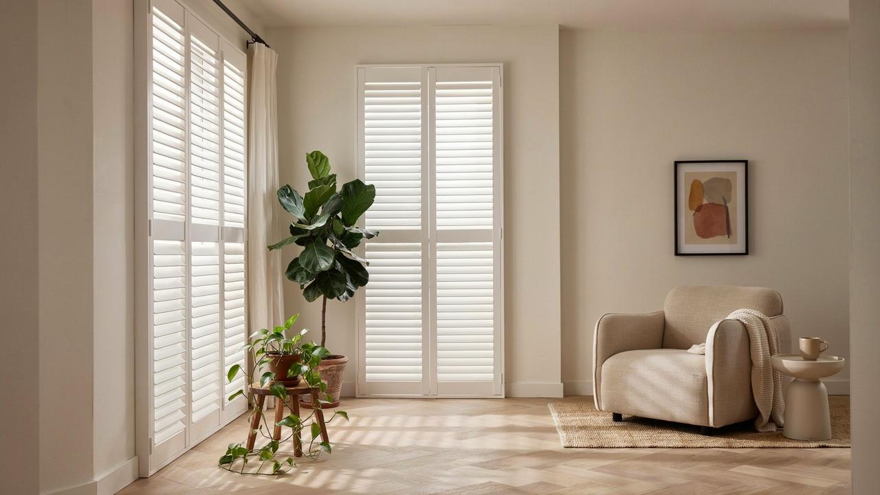 Modern living room with outside mount plantation shutters extending beyond the window frame for full coverage and a decorative look.