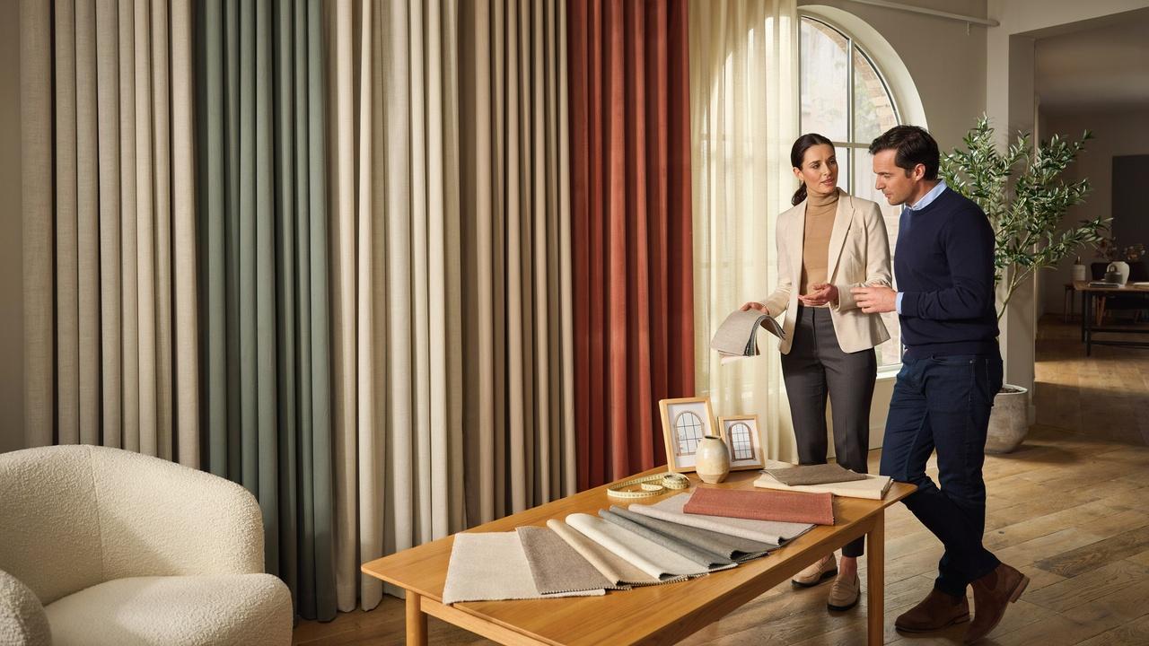 Homeowner and designer comparing different curtain pleat styles to choose the best option for a room.
