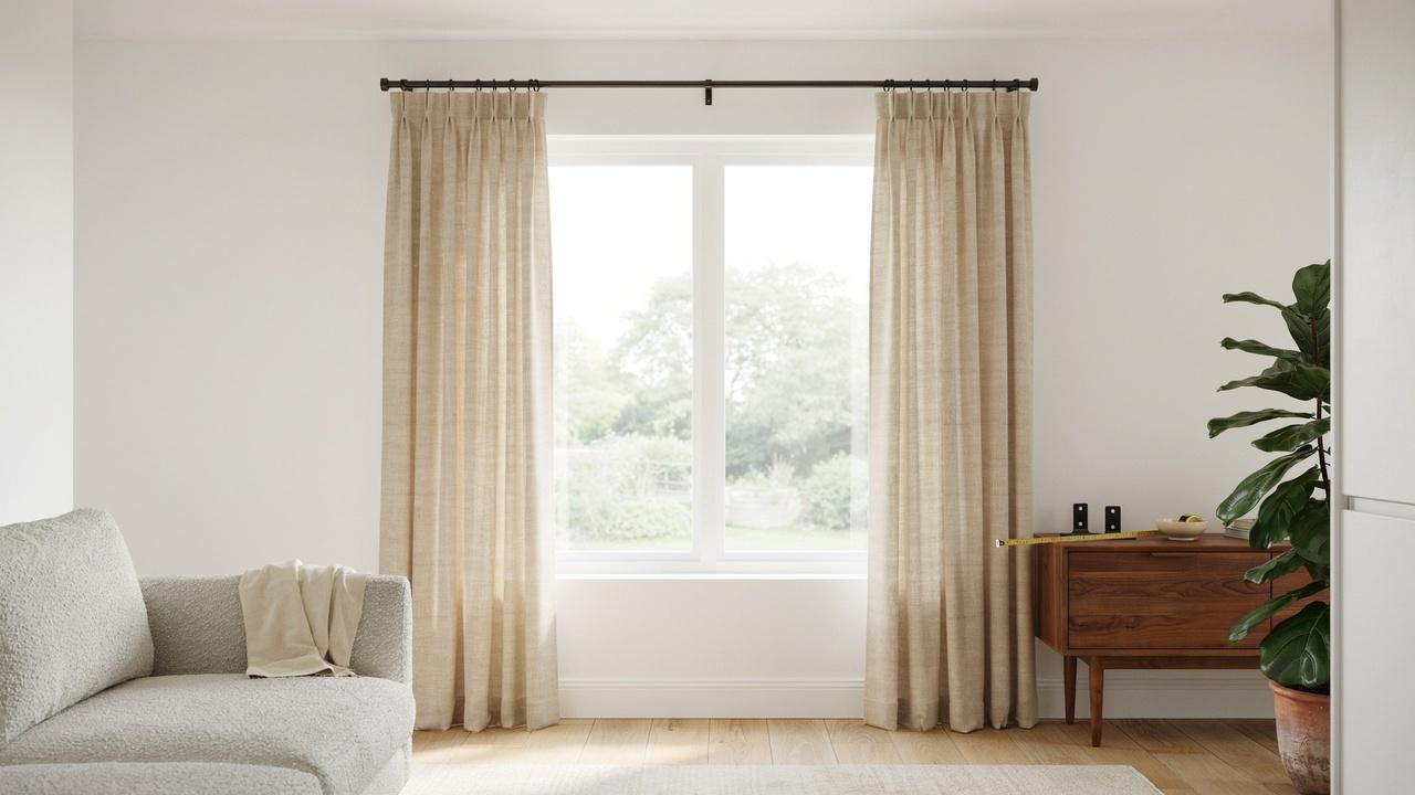 Wide window with curtain rods extending beyond the frame and curtains pulled back to illustrate ideal rod width placement.