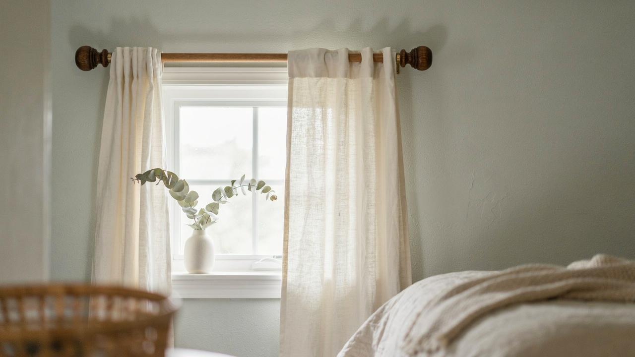 Wooden curtain rod finished with decorative drawer knob finials.