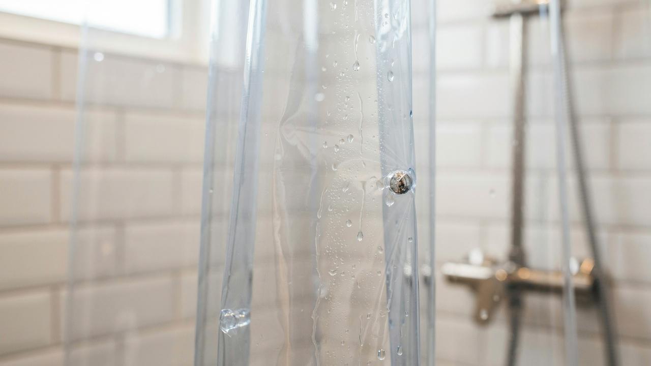Water droplets beading on a waterproof PEVA shower curtain surface.