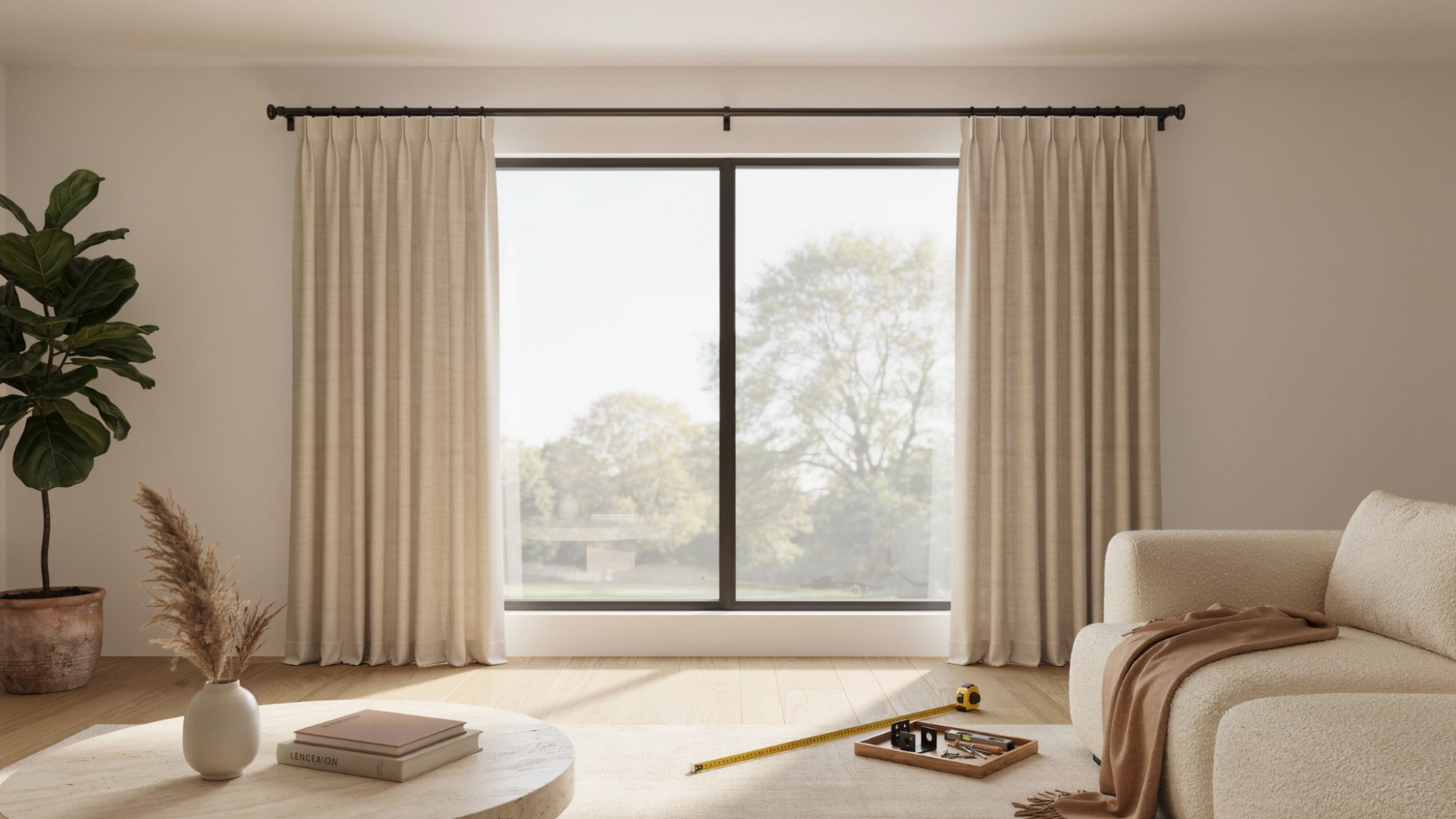 Beige pinch-pleat curtains on black rod over large window, living room with sofa, plants, tape measure on floor.
